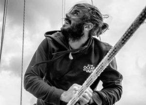 a man with a beard on a sailboat.