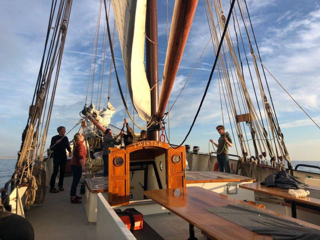 people standing on the deck of a sailboat.