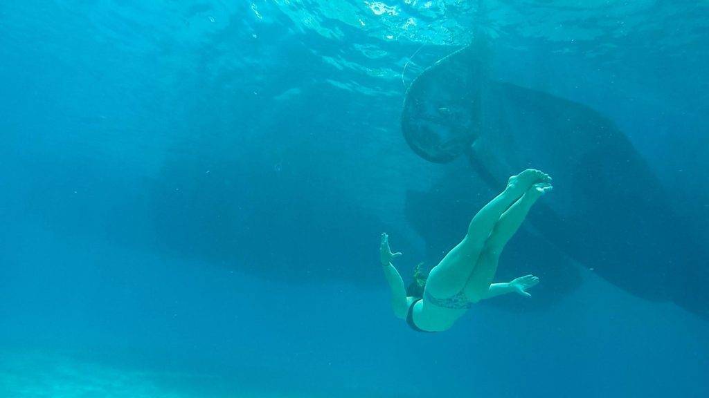 a woman in a bikini swimming in the ocean.