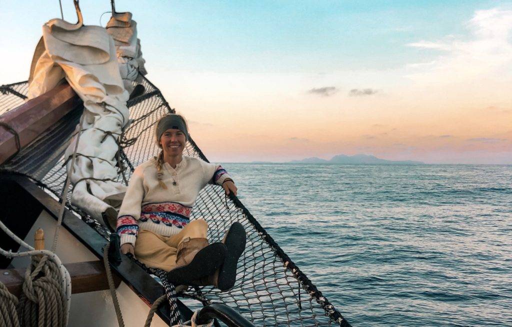 a woman sitting on the deck of a sailboat.