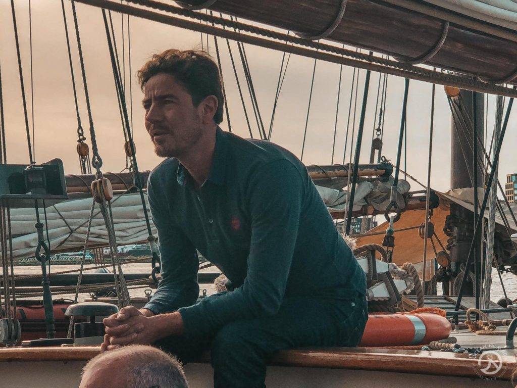 a man sitting on the deck of a sailboat.