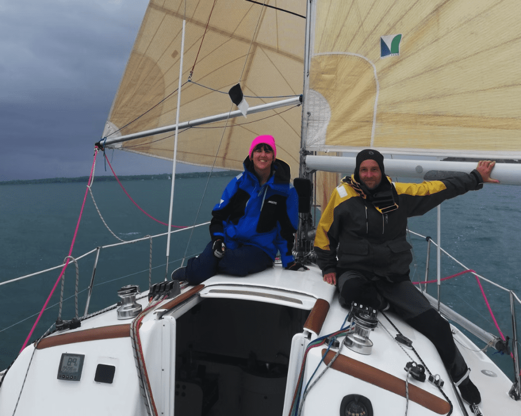 A sailing crew of two people on a sailboat.