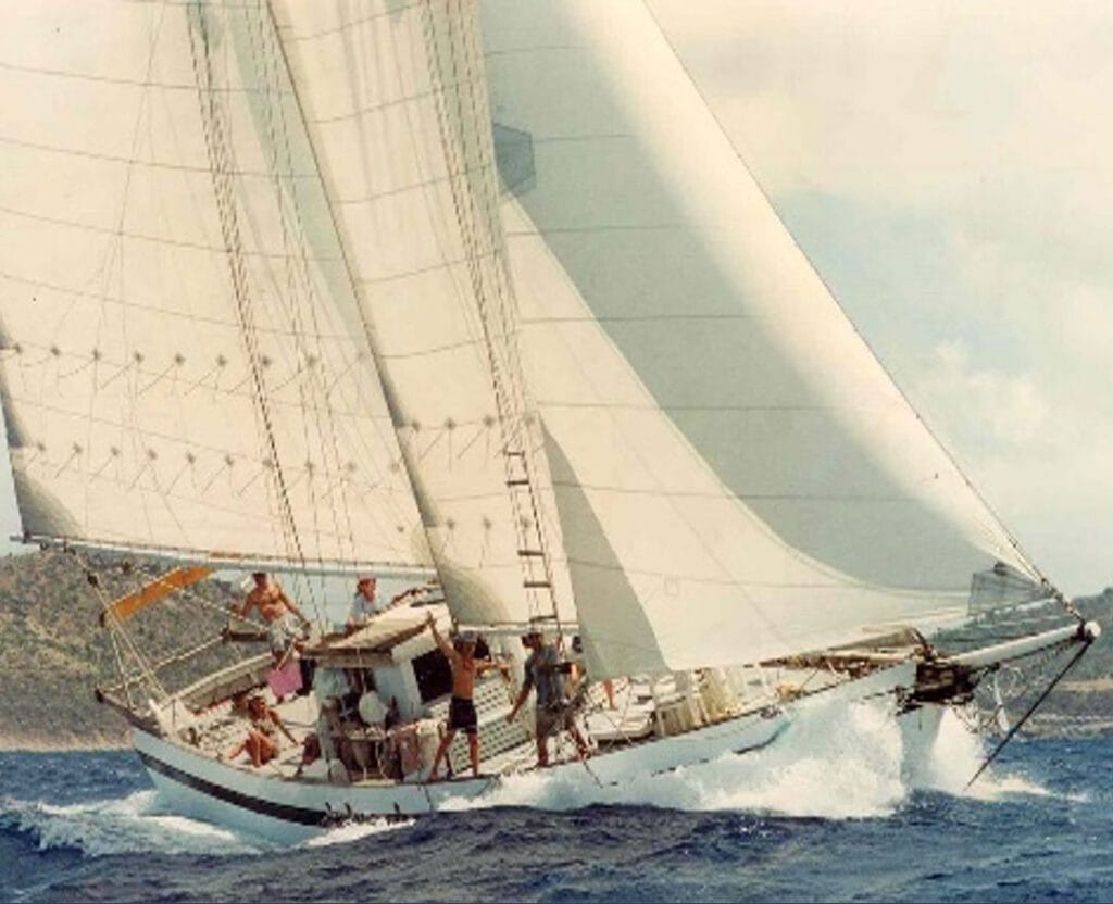 Sailing yacht heeling in strong wind with crew on deck, living their ocean dream.